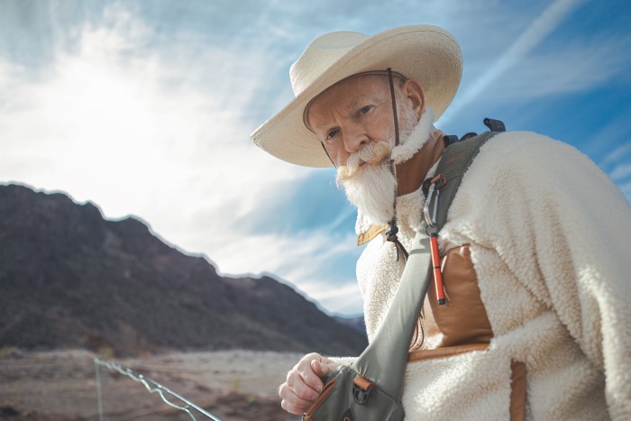 Man fishing with orange backpacker attached to carabiner