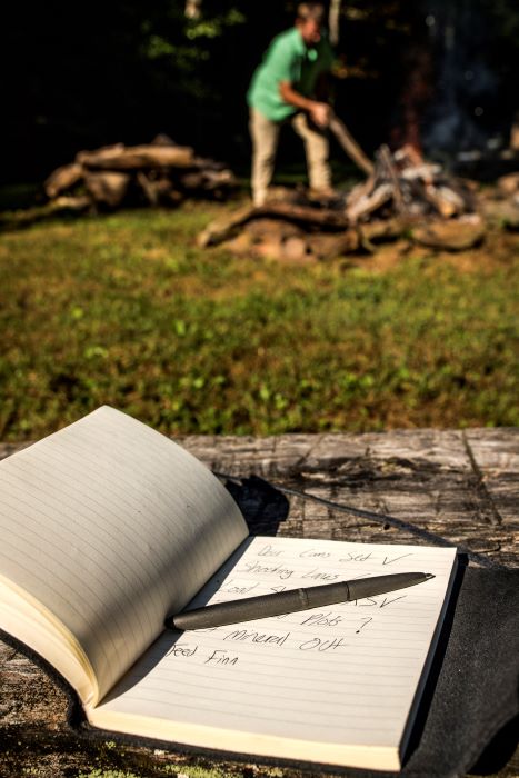 Open 400H-237 on notebook with man in background starting campfire